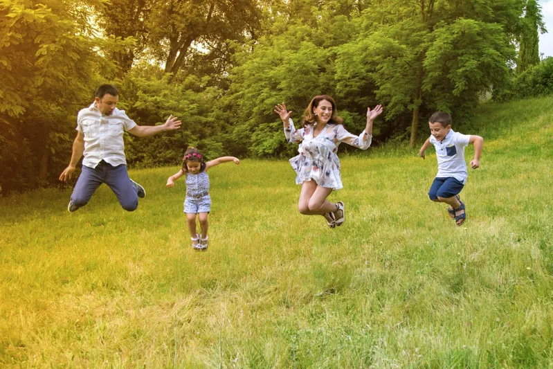 Una famiglia salta e gioca all’aperto