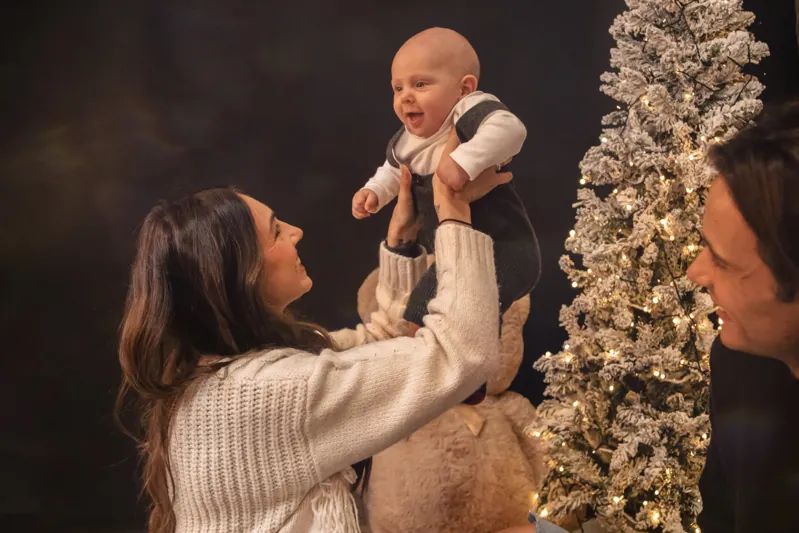 Una mamma solleva il suo bambino a Natale